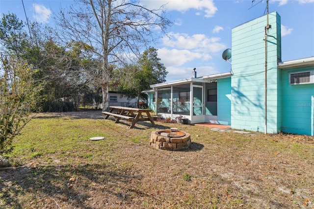 view of yard featuring a sunroom and an outdoor fire pit