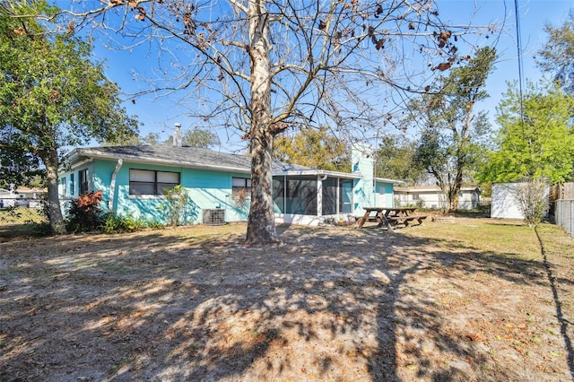 back of house featuring a sunroom and central AC