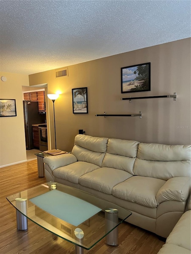 living room with hardwood / wood-style flooring and a textured ceiling