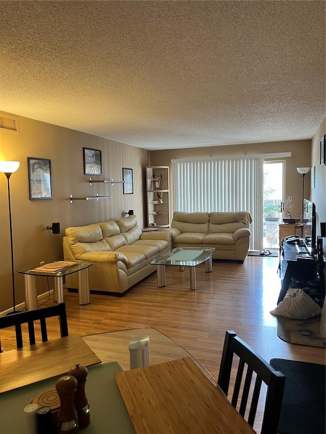 living room with hardwood / wood-style flooring and a textured ceiling