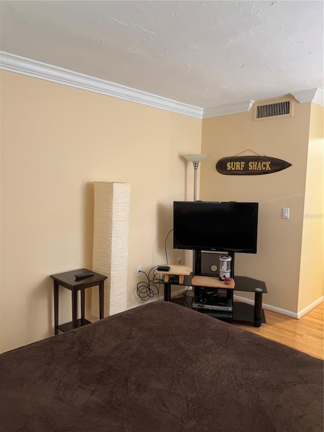 bedroom with crown molding and wood-type flooring