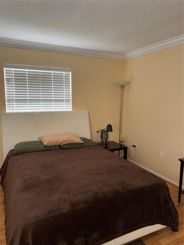 bedroom featuring hardwood / wood-style floors and ornamental molding