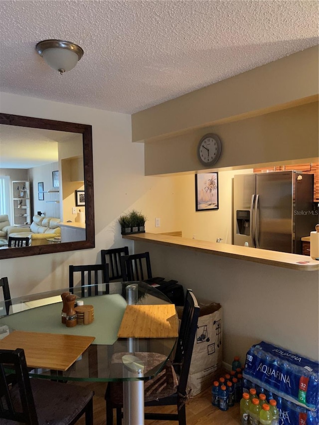 dining room featuring hardwood / wood-style floors and a textured ceiling