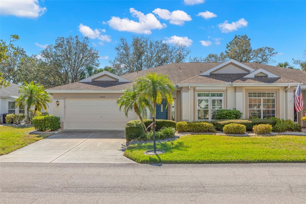 ranch-style house featuring a garage and a front yard