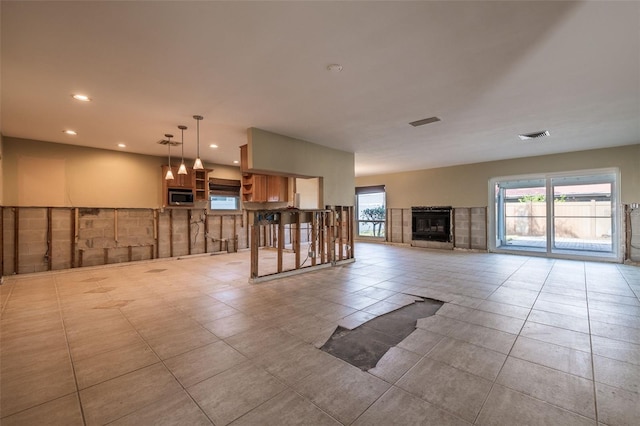 unfurnished living room with a fireplace and light tile patterned flooring