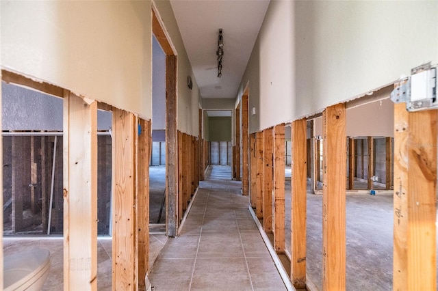 hallway with track lighting and tile patterned floors