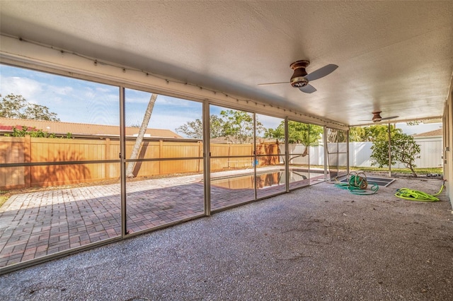 unfurnished sunroom with ceiling fan