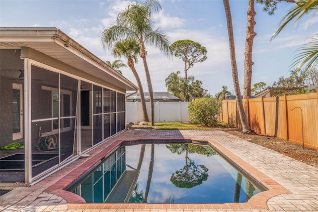 view of swimming pool featuring a sunroom and a patio area