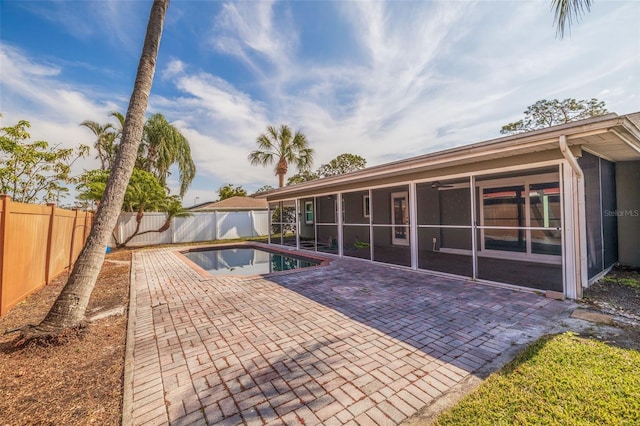 view of swimming pool with a sunroom and a patio area