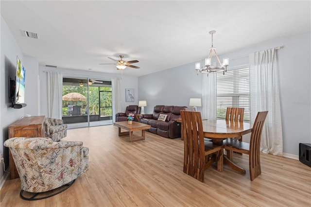 dining area featuring ceiling fan with notable chandelier and light wood-type flooring