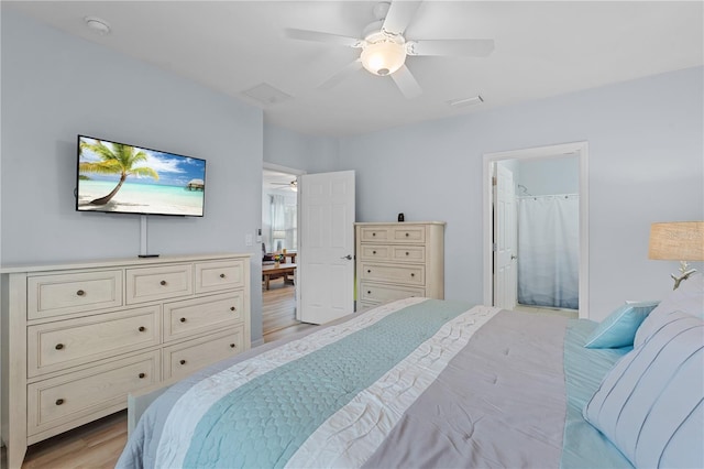 bedroom with light hardwood / wood-style flooring, ceiling fan, and ensuite bathroom