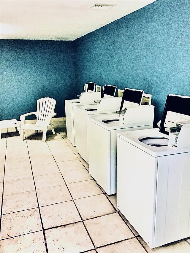 common laundry area with visible vents, washer and dryer, and light tile patterned flooring