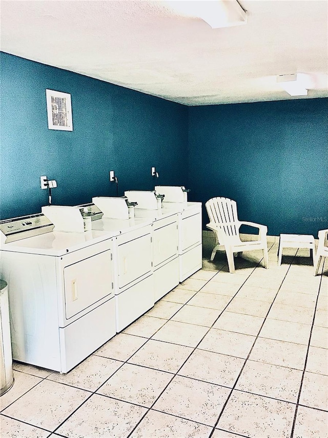 community laundry room with light tile patterned floors, independent washer and dryer, and visible vents