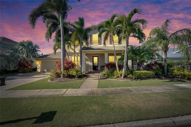 view of front of home with a garage and a lawn