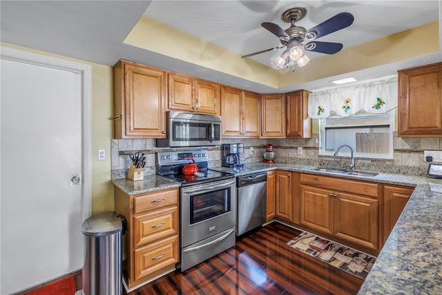 kitchen with sink, stone countertops, appliances with stainless steel finishes, dark hardwood / wood-style floors, and backsplash