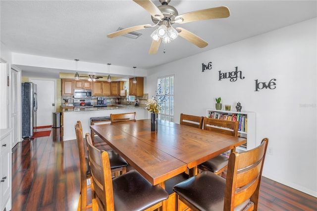 dining room with ceiling fan and dark hardwood / wood-style flooring