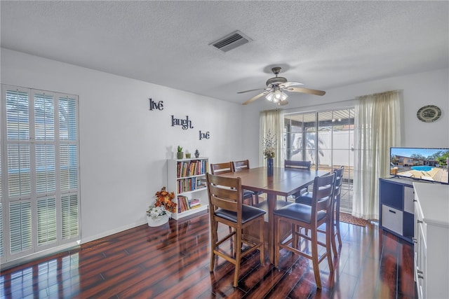 dining area featuring ceiling fan, a textured ceiling, and dark hardwood / wood-style flooring