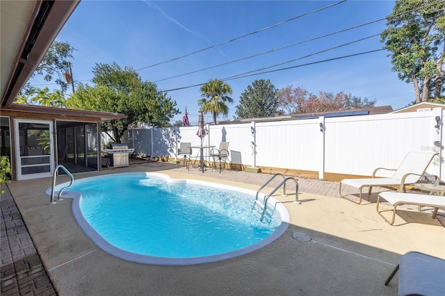 view of pool with a sunroom and a patio area