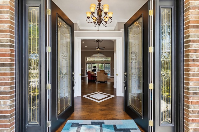 foyer entrance featuring ornamental molding, an inviting chandelier, dark hardwood / wood-style flooring, and french doors