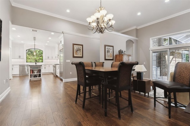 dining room with ornamental molding, dark hardwood / wood-style flooring, sink, and a notable chandelier