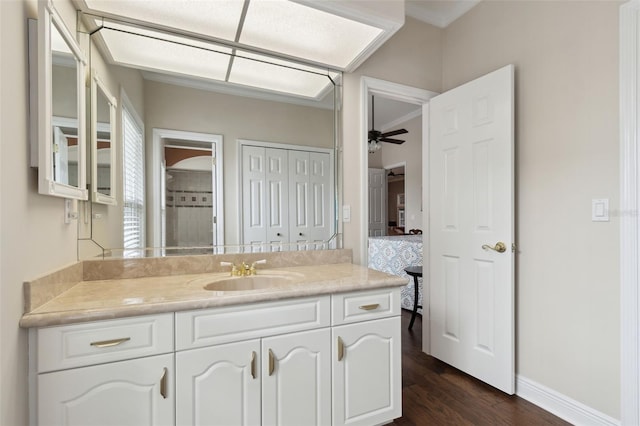 bathroom with hardwood / wood-style flooring, ceiling fan, vanity, and ornamental molding