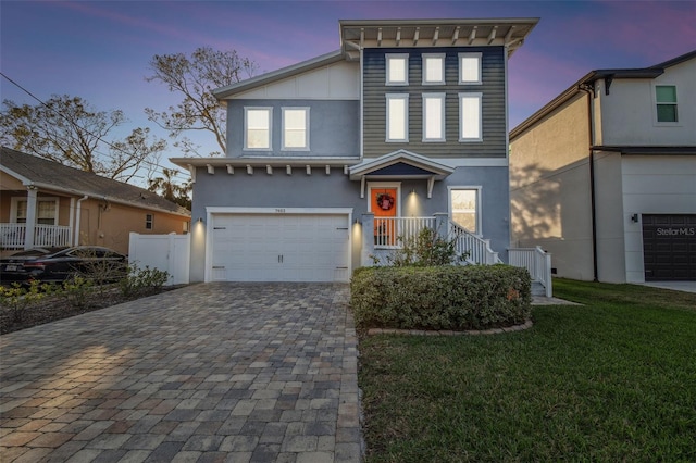 view of front of house featuring a garage and a yard