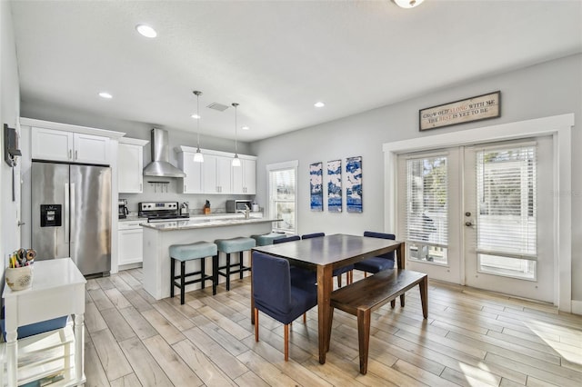 dining room with french doors and light hardwood / wood-style floors