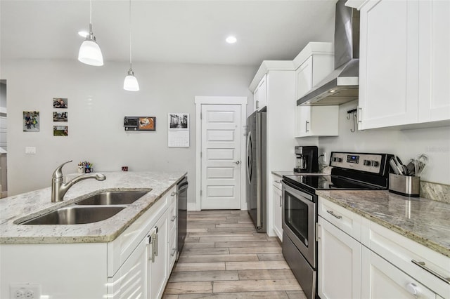 kitchen featuring pendant lighting, sink, appliances with stainless steel finishes, white cabinetry, and wall chimney exhaust hood