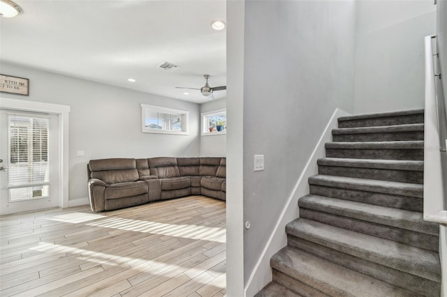 staircase featuring wood-type flooring and ceiling fan