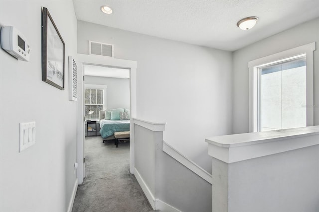 corridor featuring carpet floors and a textured ceiling