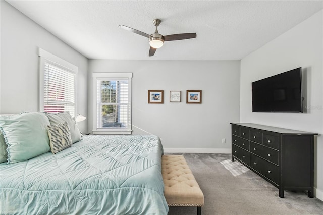 carpeted bedroom with ceiling fan and a textured ceiling