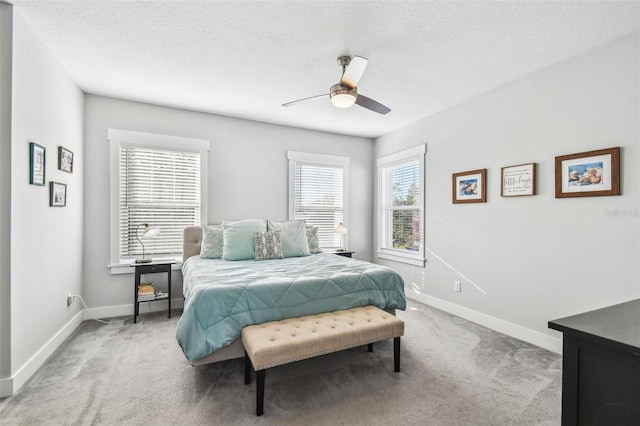 carpeted bedroom with ceiling fan and a textured ceiling