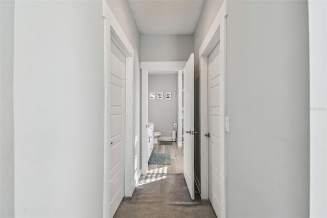 hall with dark colored carpet