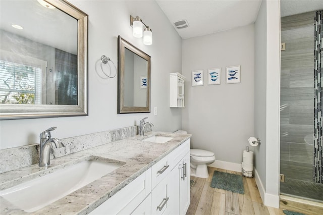 bathroom with vanity, hardwood / wood-style floors, a shower with shower door, and toilet