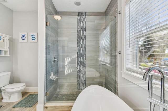 bathroom featuring a shower with door and toilet