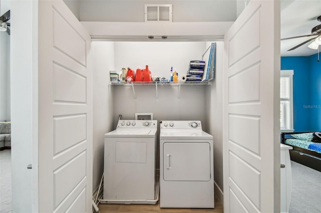 clothes washing area featuring washer and dryer, ceiling fan, and light hardwood / wood-style flooring