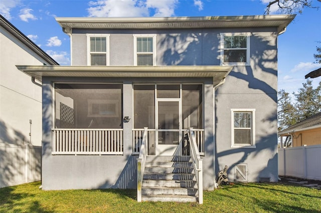 view of property featuring a front lawn and a sunroom