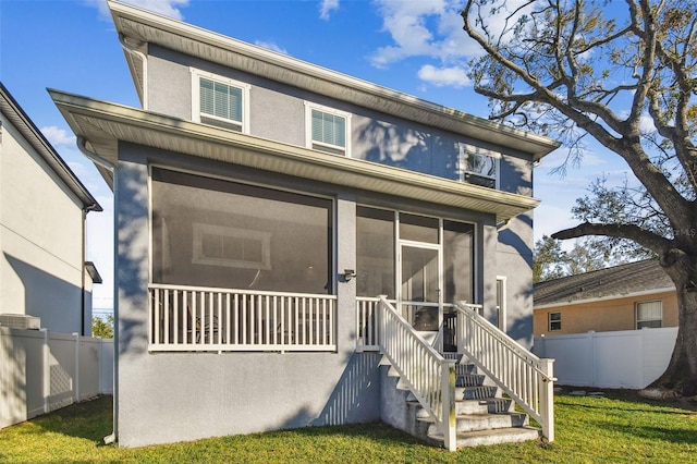 view of front of home with a front lawn and a sunroom