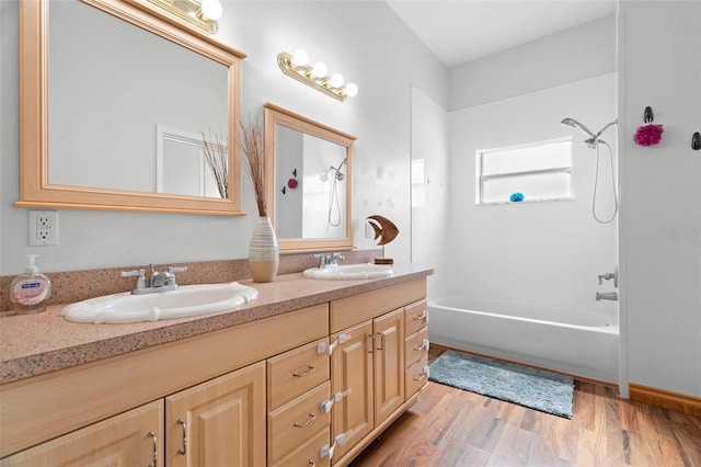 bathroom featuring hardwood / wood-style flooring, shower / washtub combination, and vanity