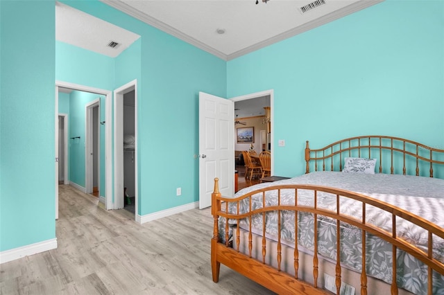 bedroom with ornamental molding, light hardwood / wood-style floors, and a closet