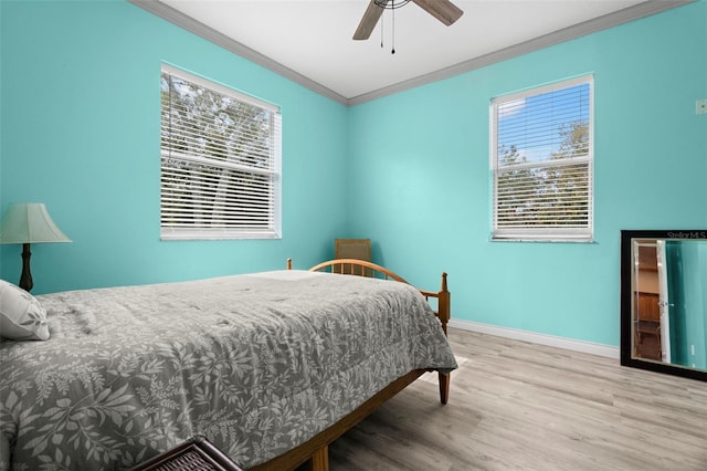 bedroom with multiple windows, ornamental molding, ceiling fan, and light wood-type flooring