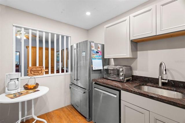 kitchen featuring white cabinetry, sink, dark stone counters, and appliances with stainless steel finishes