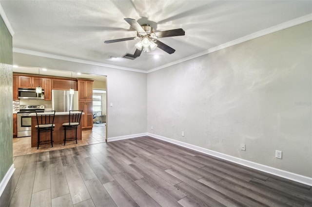 unfurnished living room featuring crown molding, ceiling fan, and hardwood / wood-style floors