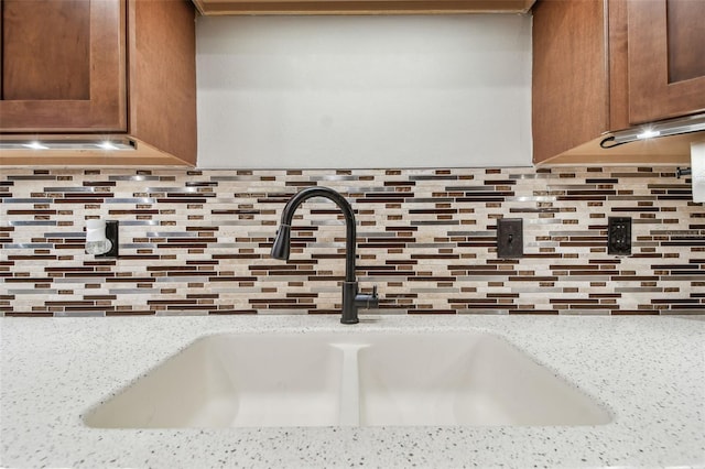 room details with light stone countertops and sink