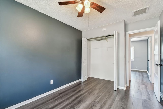 unfurnished bedroom featuring hardwood / wood-style flooring, ceiling fan, a textured ceiling, and a closet