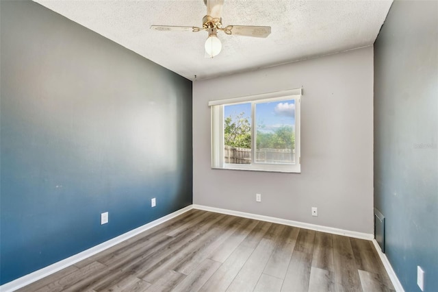 empty room with ceiling fan, hardwood / wood-style floors, and a textured ceiling