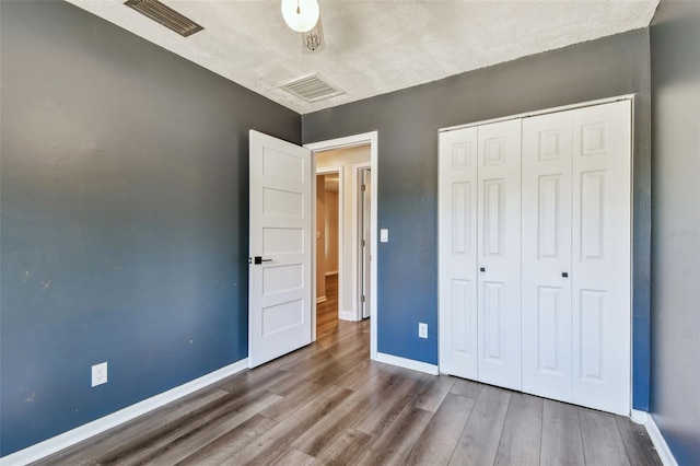 unfurnished bedroom with hardwood / wood-style flooring and a closet