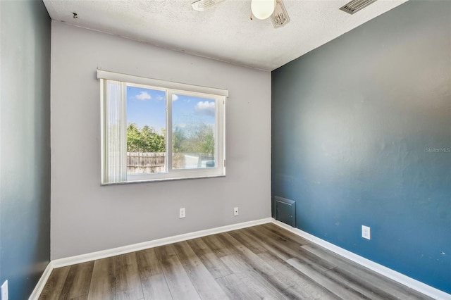 unfurnished room featuring ceiling fan, hardwood / wood-style floors, and a textured ceiling