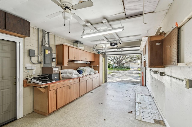 garage with a garage door opener, electric panel, and ceiling fan