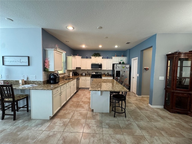 20314 Starfinder Way, Tampa, FL 33647 - kitchen featuring stainless steel appliances, a breakfast bar, sink, and dark stone counters